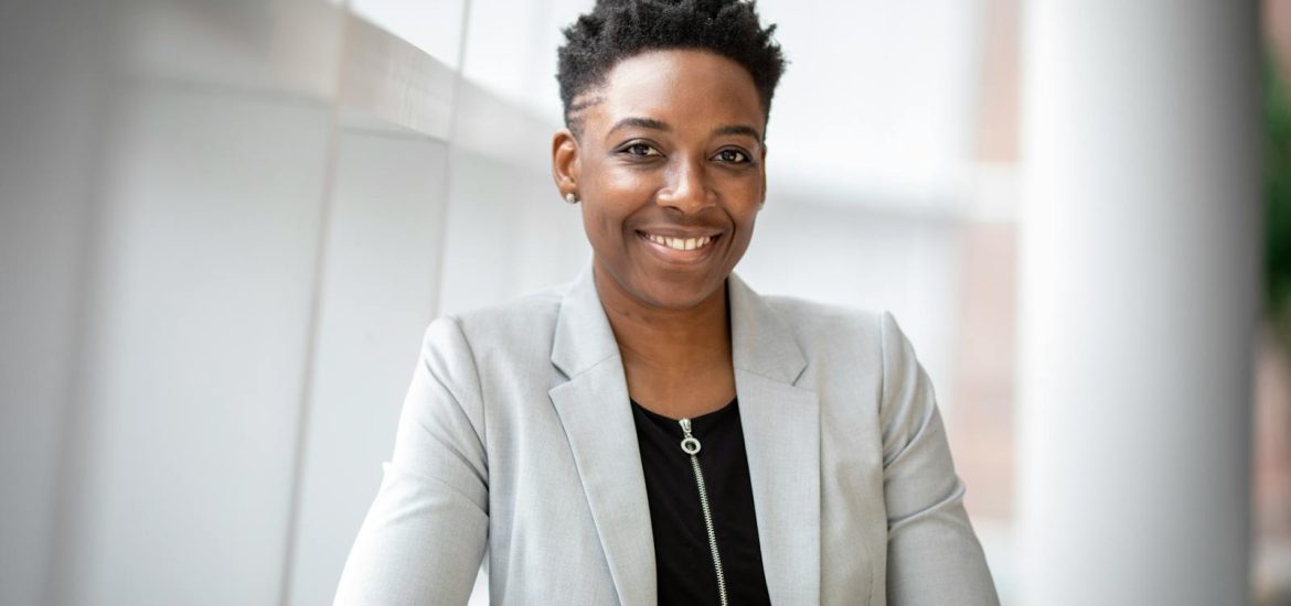 Confident African American businesswoman smiling inside a modern office space.