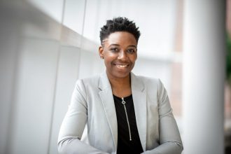 Confident African American businesswoman smiling inside a modern office space.